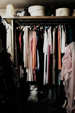 Closet filled with neatly hung clothing in a variety of colors, showcasing an organized space for wardrobe essentials.