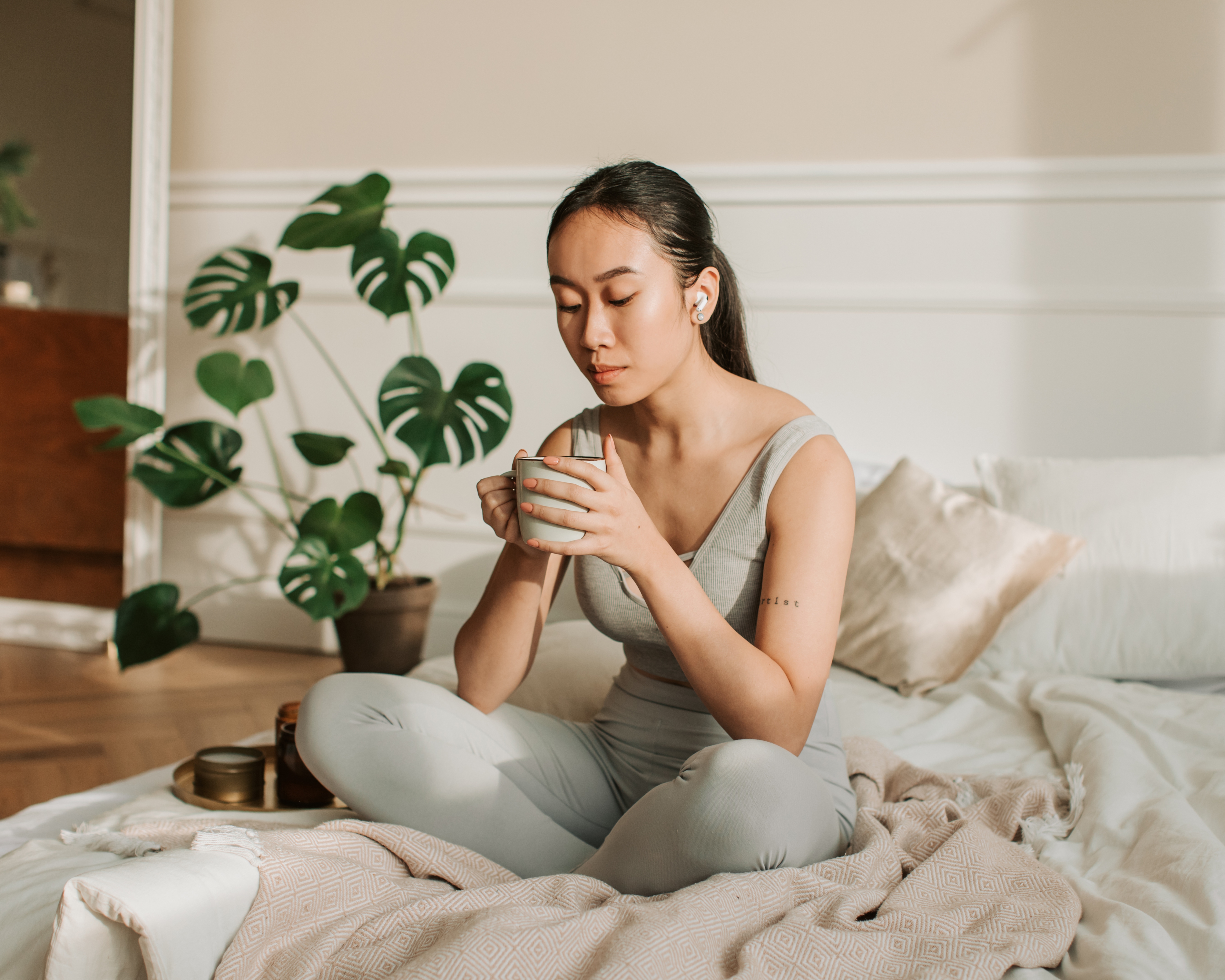 Woman relaxing in bed enjoying a cup of coffee